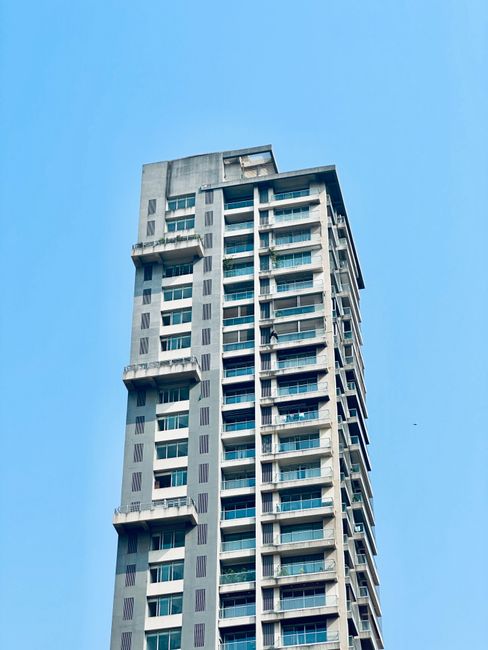 A striking high-rise building set against a clear blue sky, showcasing modern urban architecture.
